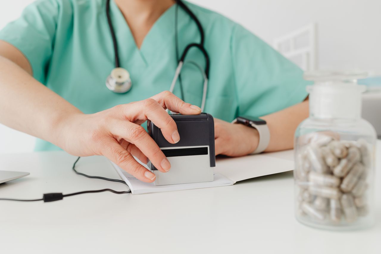 Mastering the First Impression: Your intriguing post title goes here Close-up of a doctor stamping a prescription with a bottle of pills on a desk.